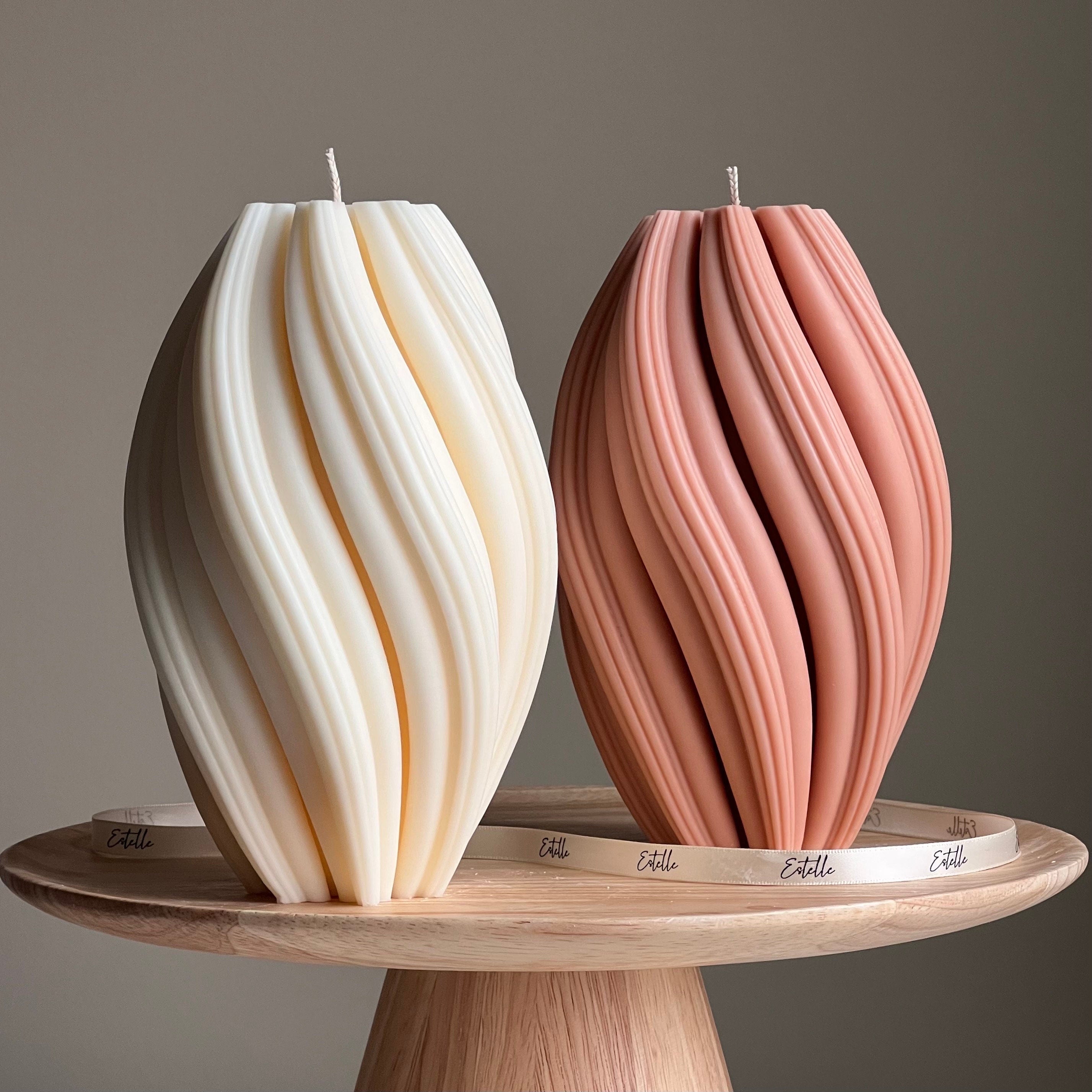Two unique candle designs on a wooden stand with a neutral background