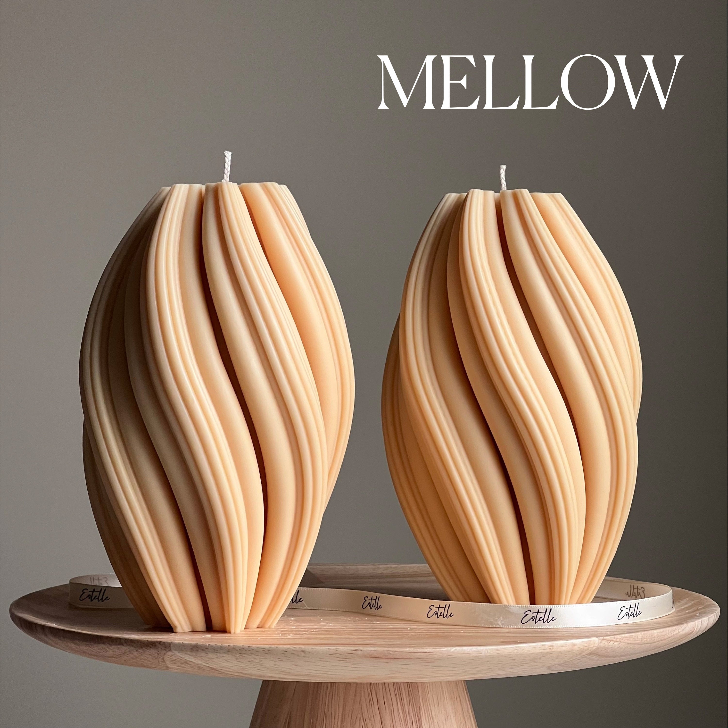 Two wooden-textured candles on a wooden stand with 'Mellow' branding.