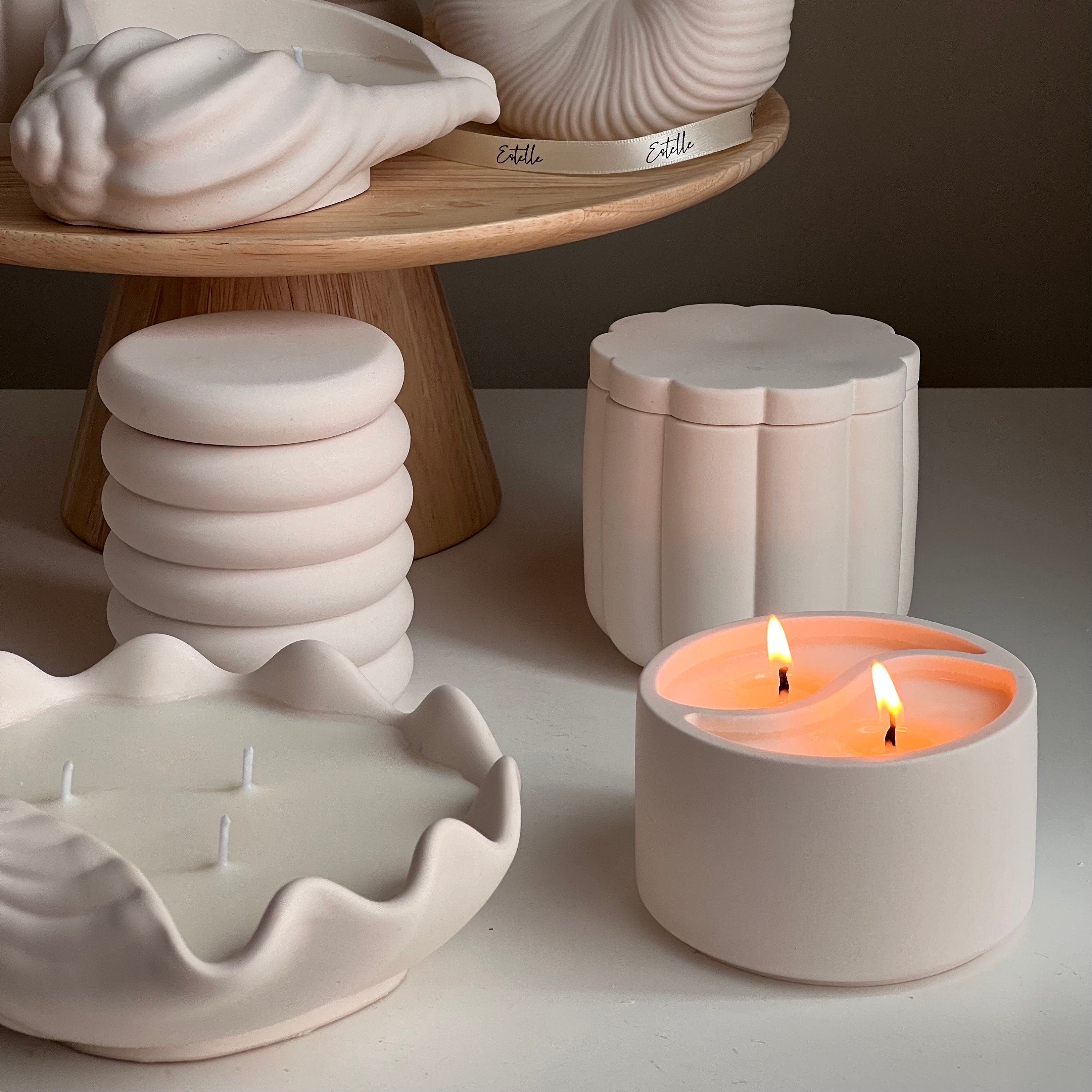 Ceramic containers with candles on a neutral background