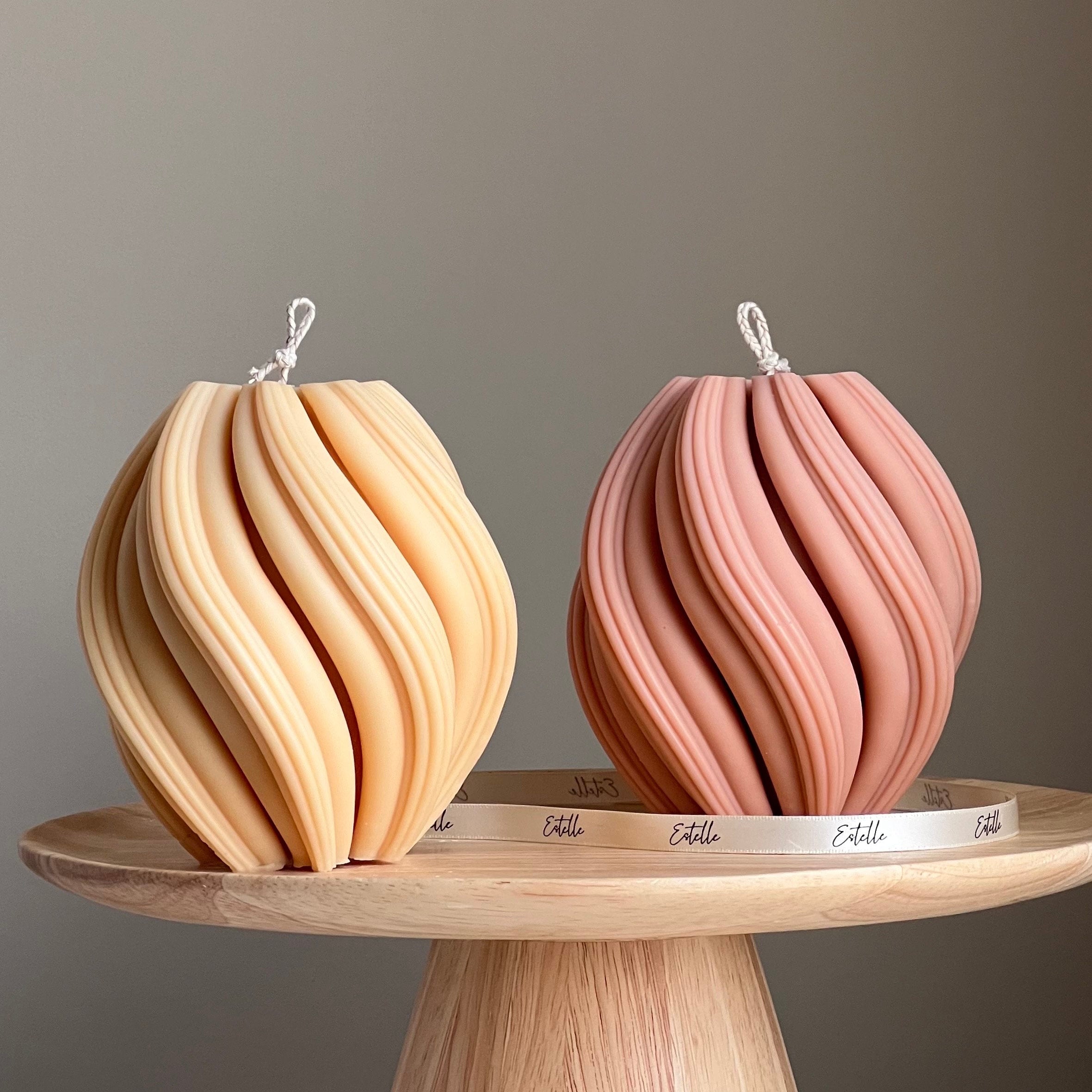 Two decorative items on a wooden stand with a neutral background