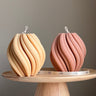 Two decorative items on a wooden stand with a neutral background