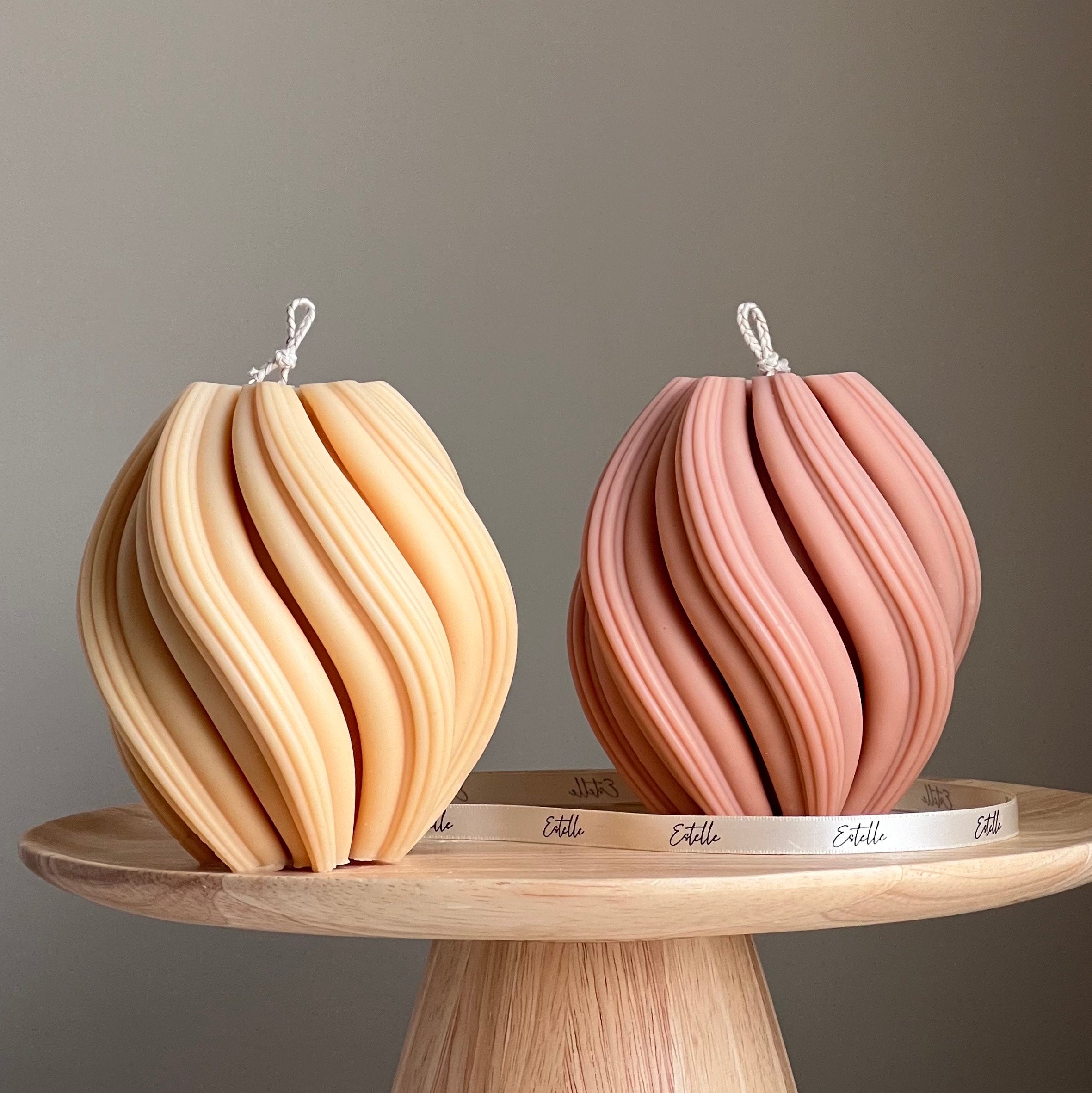 Two decorative items on a wooden stand with a neutral background