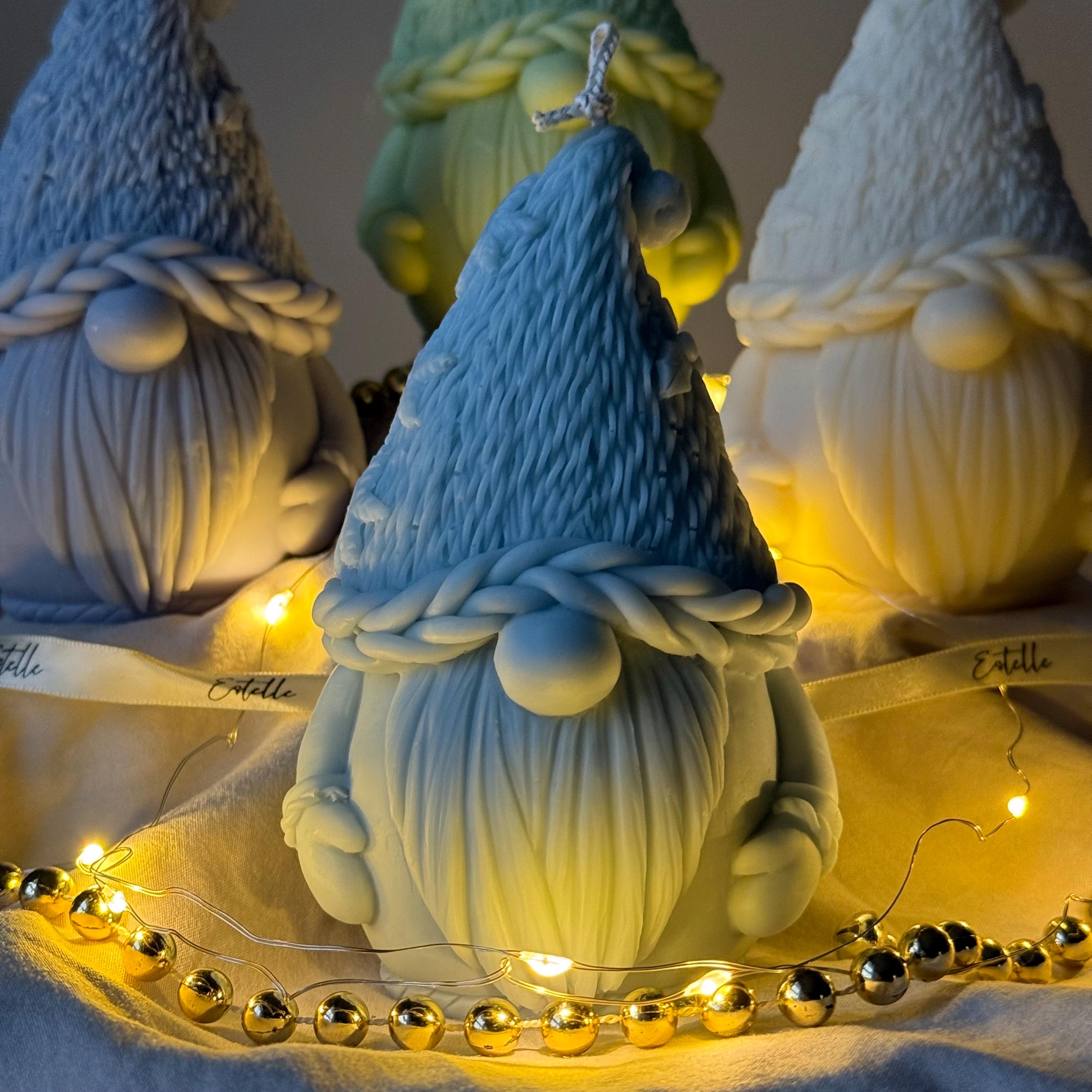 Decorative gnomes with braided hats on a table with string lights.