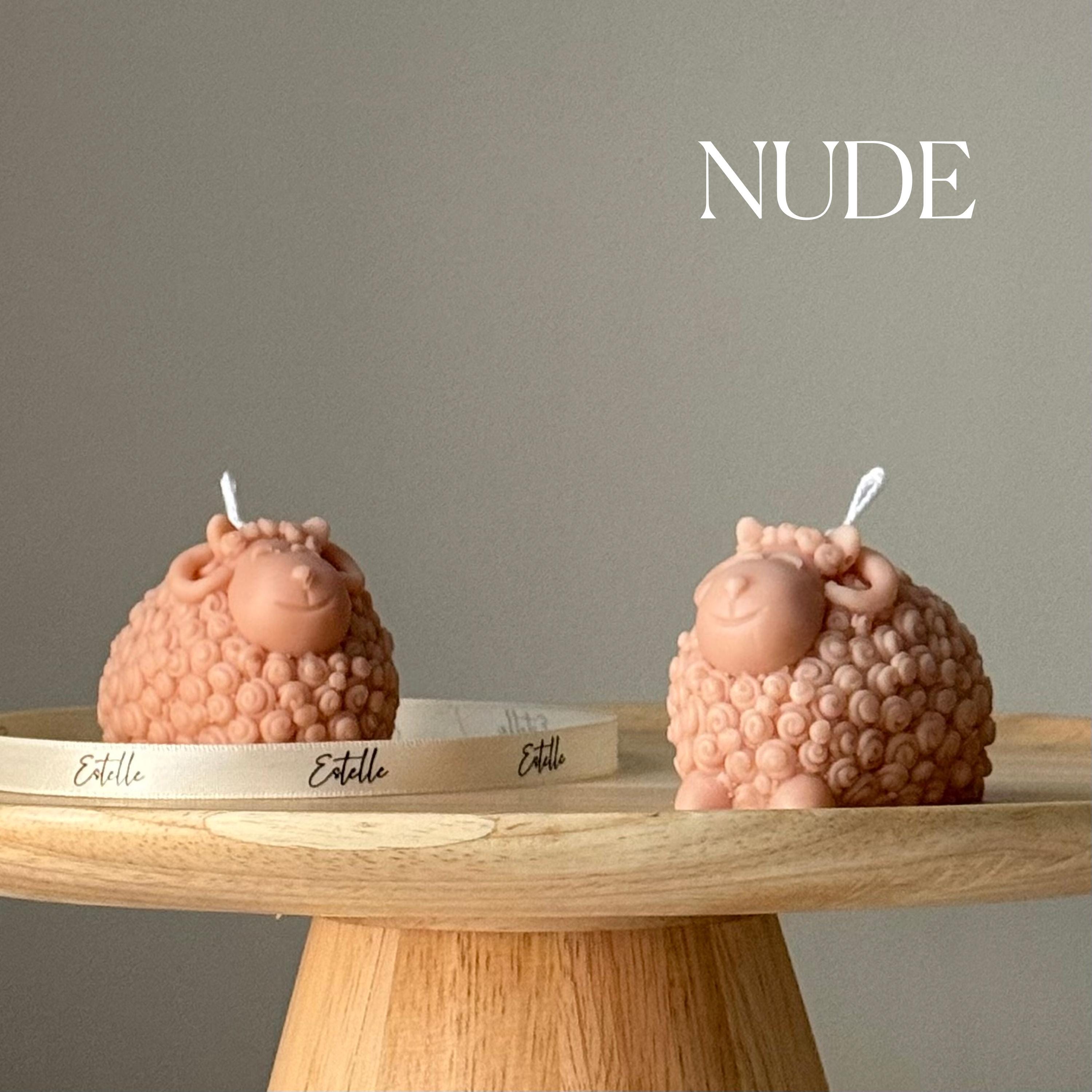 Two pink textured candles on a wooden stand with 'Estelle' branding against a gray background.