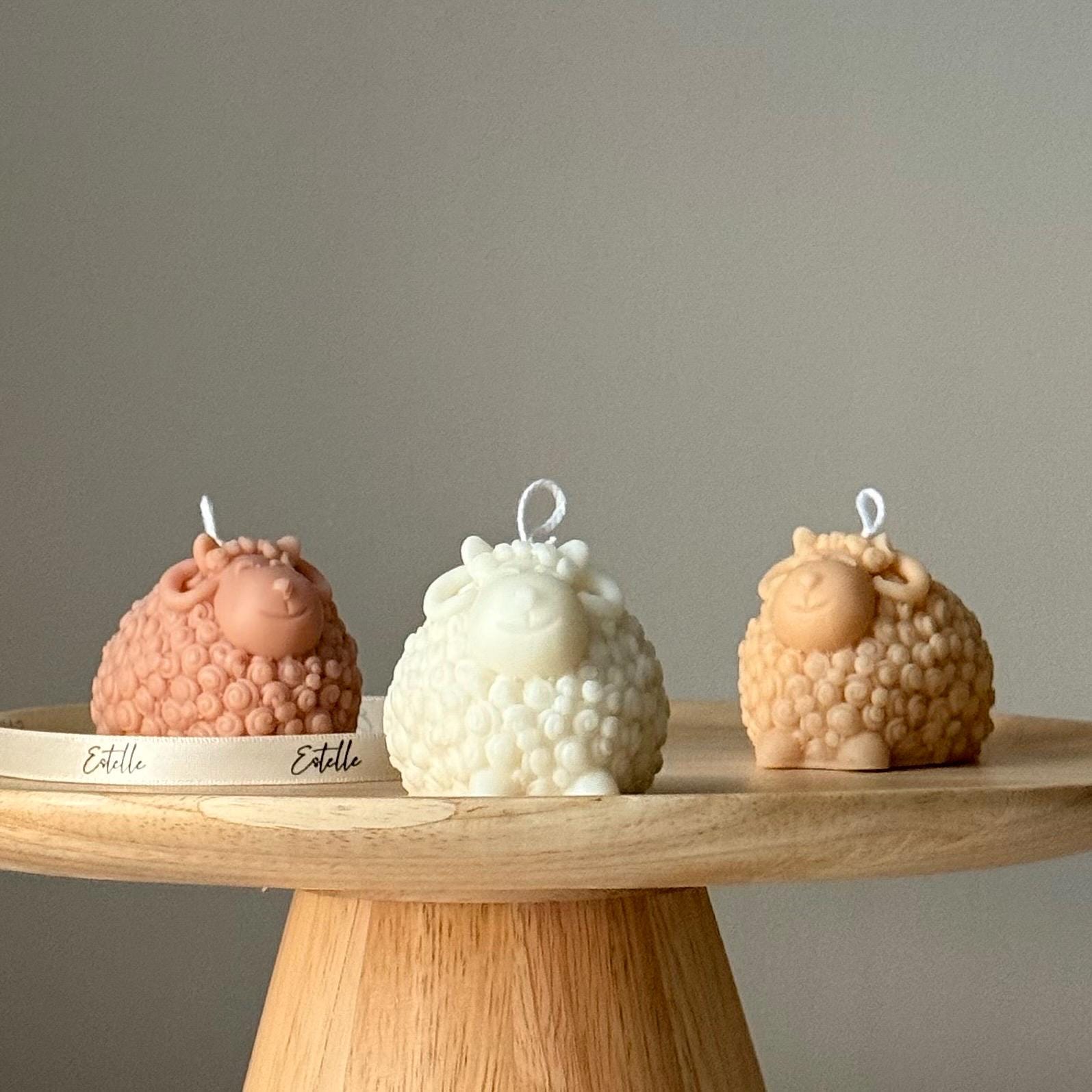 Three textured candles on a wooden stand with a neutral background