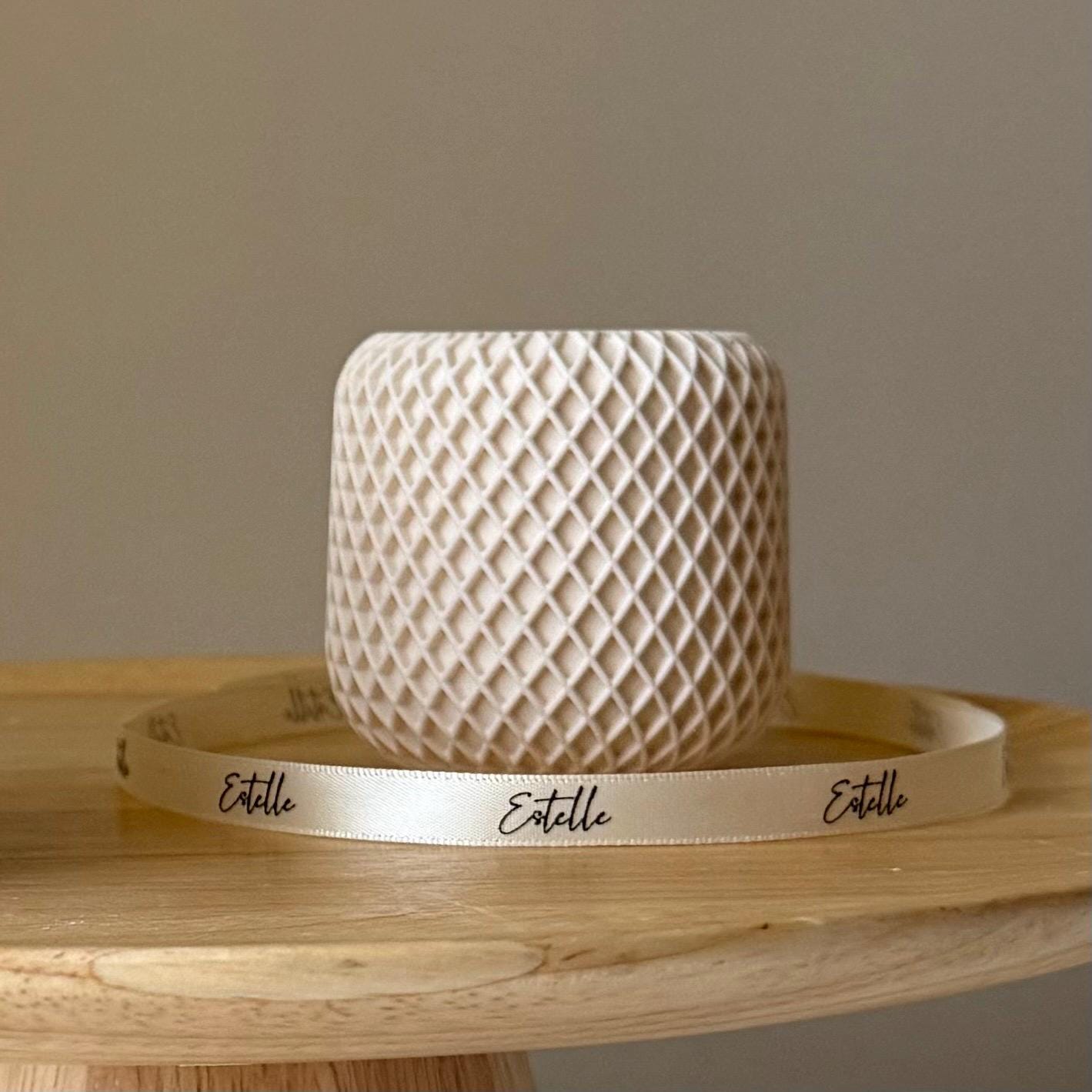 Beige woven hat with a matching band on a wooden surface