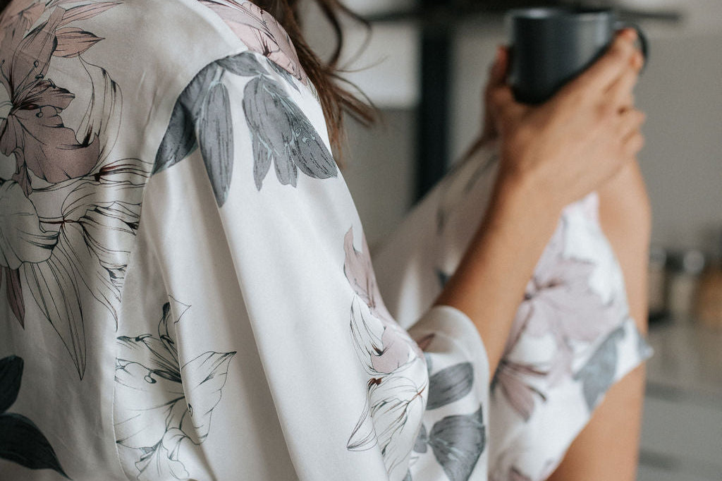 Woman in a floral robe holding a mug in a kitchen setting