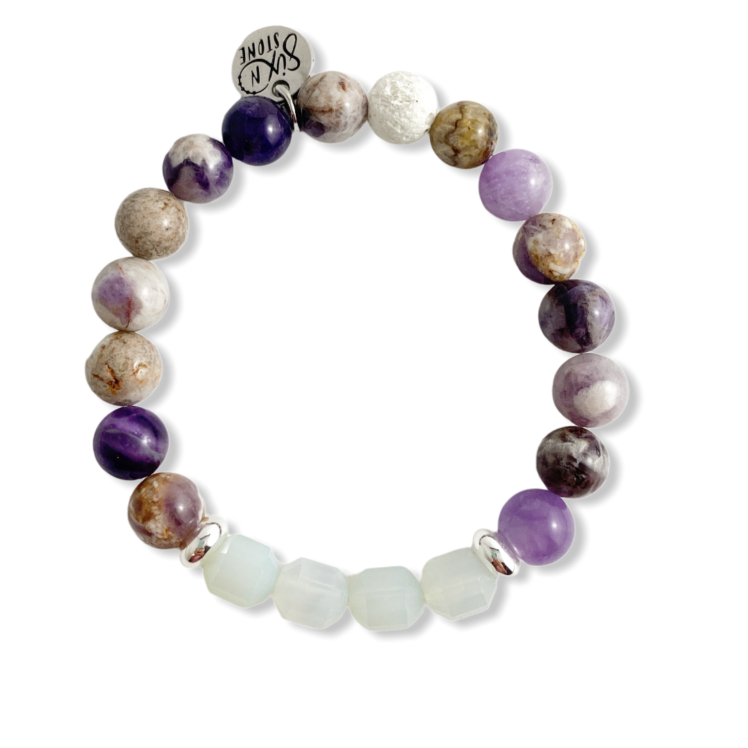 Multicolored beaded bracelet with a silver charm on a white background