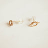 Gold knot earrings on a light beige background