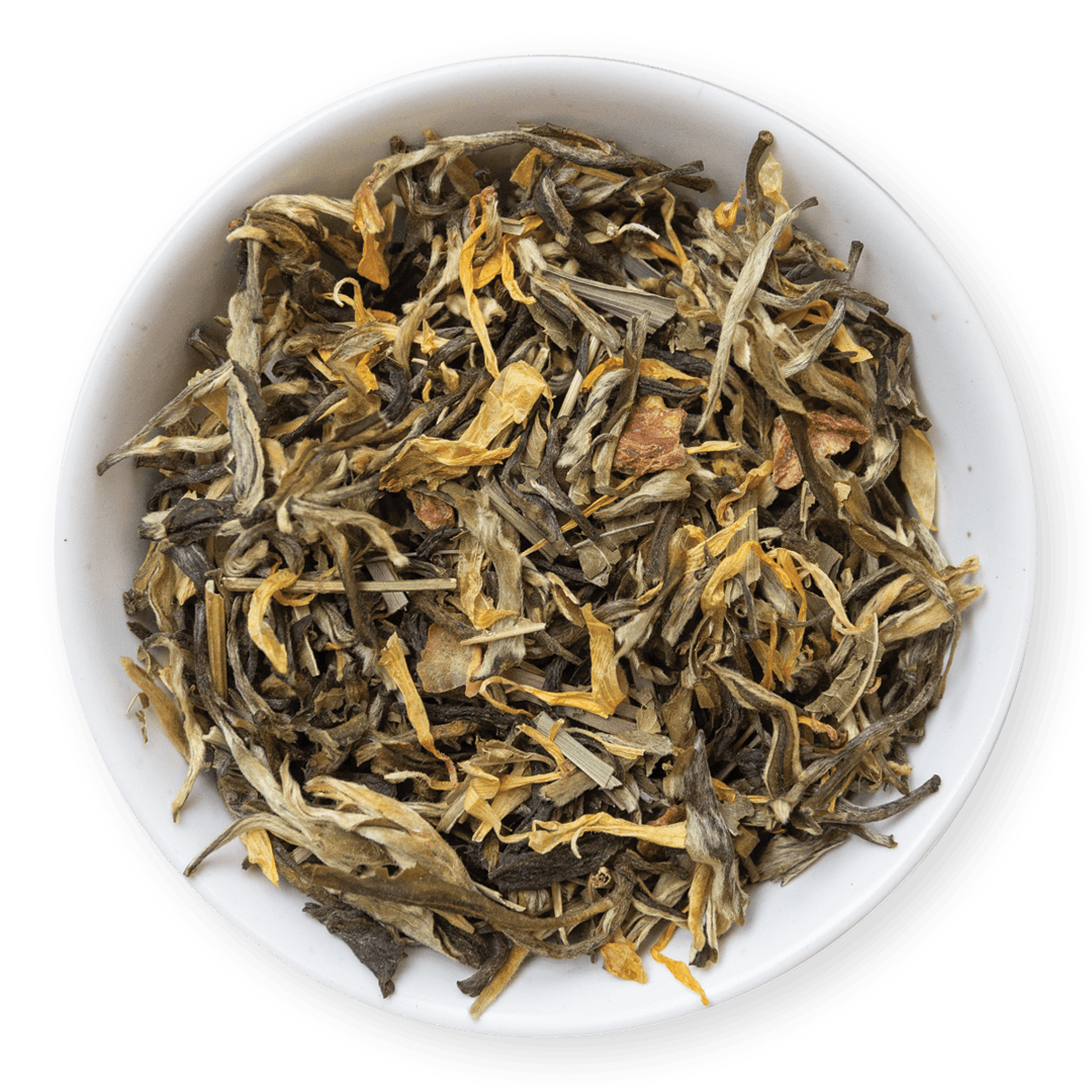 Dry tea leaves in a white bowl on a dark background