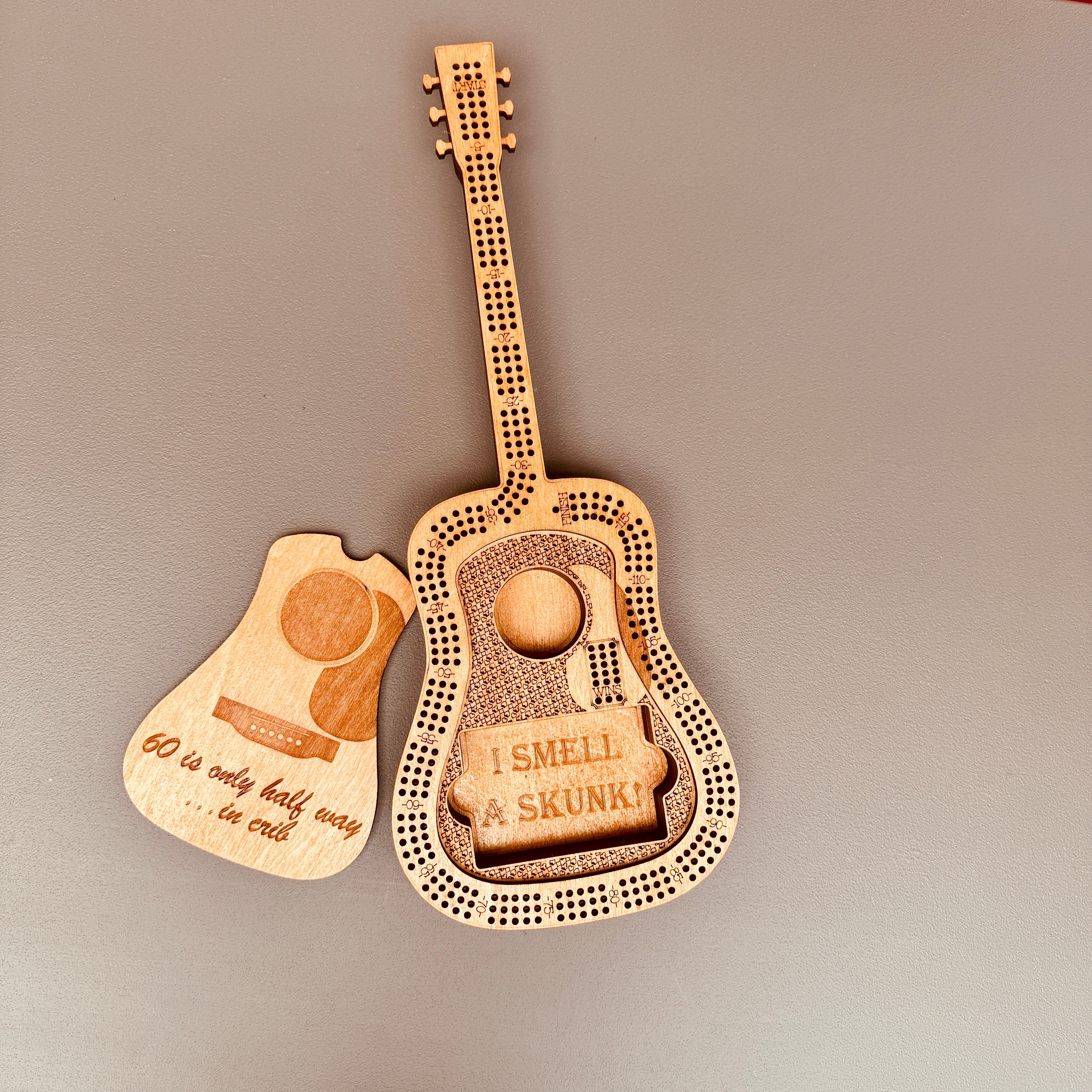 Wooden guitar-shaped novelty item with humorous text on a gray background