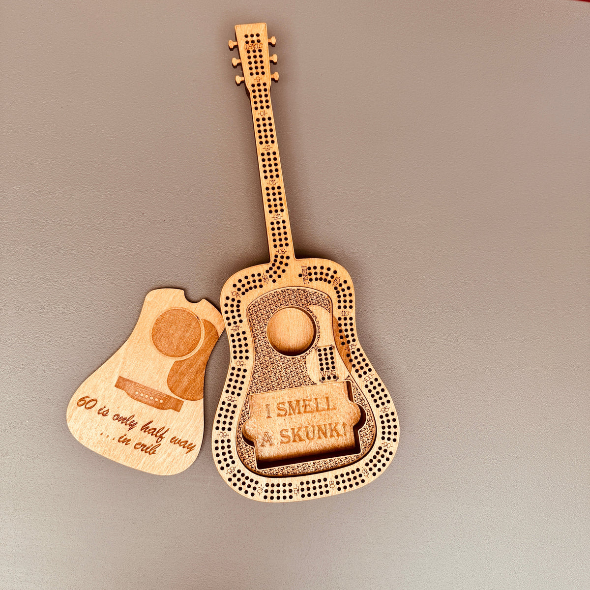 Wooden guitar-shaped novelty item with humorous text on a gray background