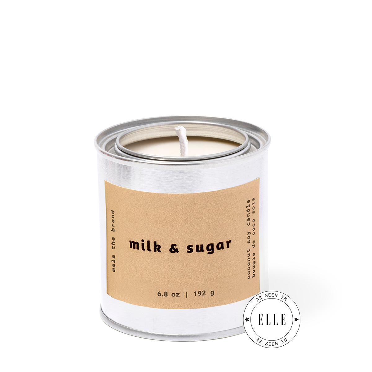 Candle in a metal container with a brown label reading 'milk & sugar' on a white background.