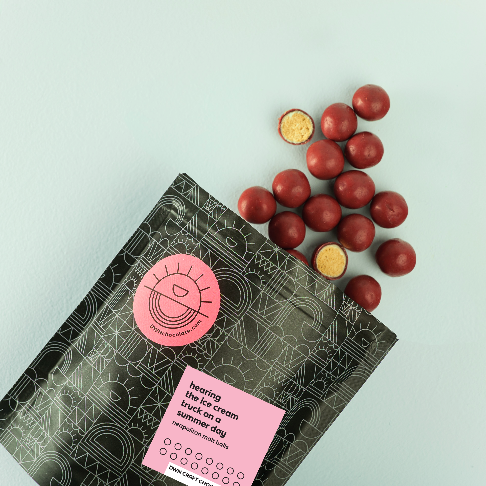 DWN Craft Chocolatier neapolitan malt balls with a pink label on a light blue background