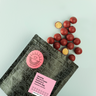 DWN Craft Chocolatier neapolitan malt balls with a pink label on a light blue background