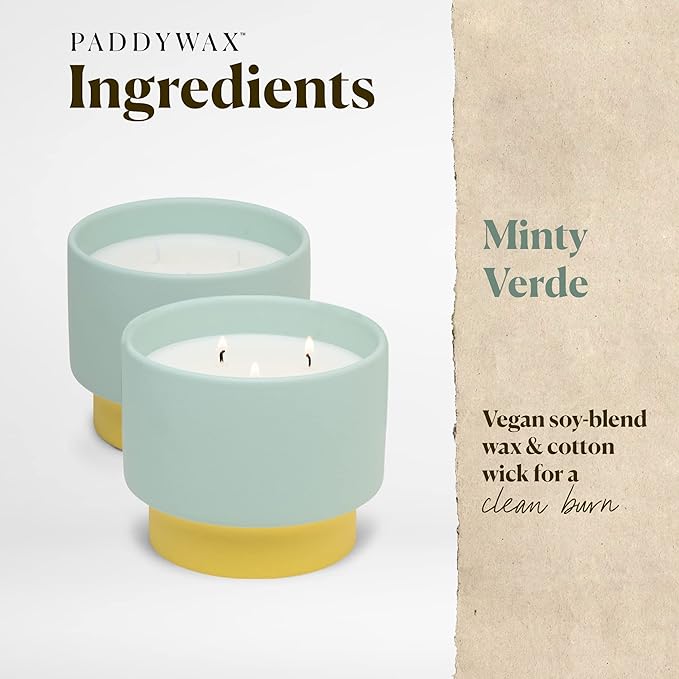 Two mint green candles with yellow bases on a white background, featuring Paddywax branding and product details.