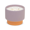 Candle in a purple container with a terracotta base on a white background