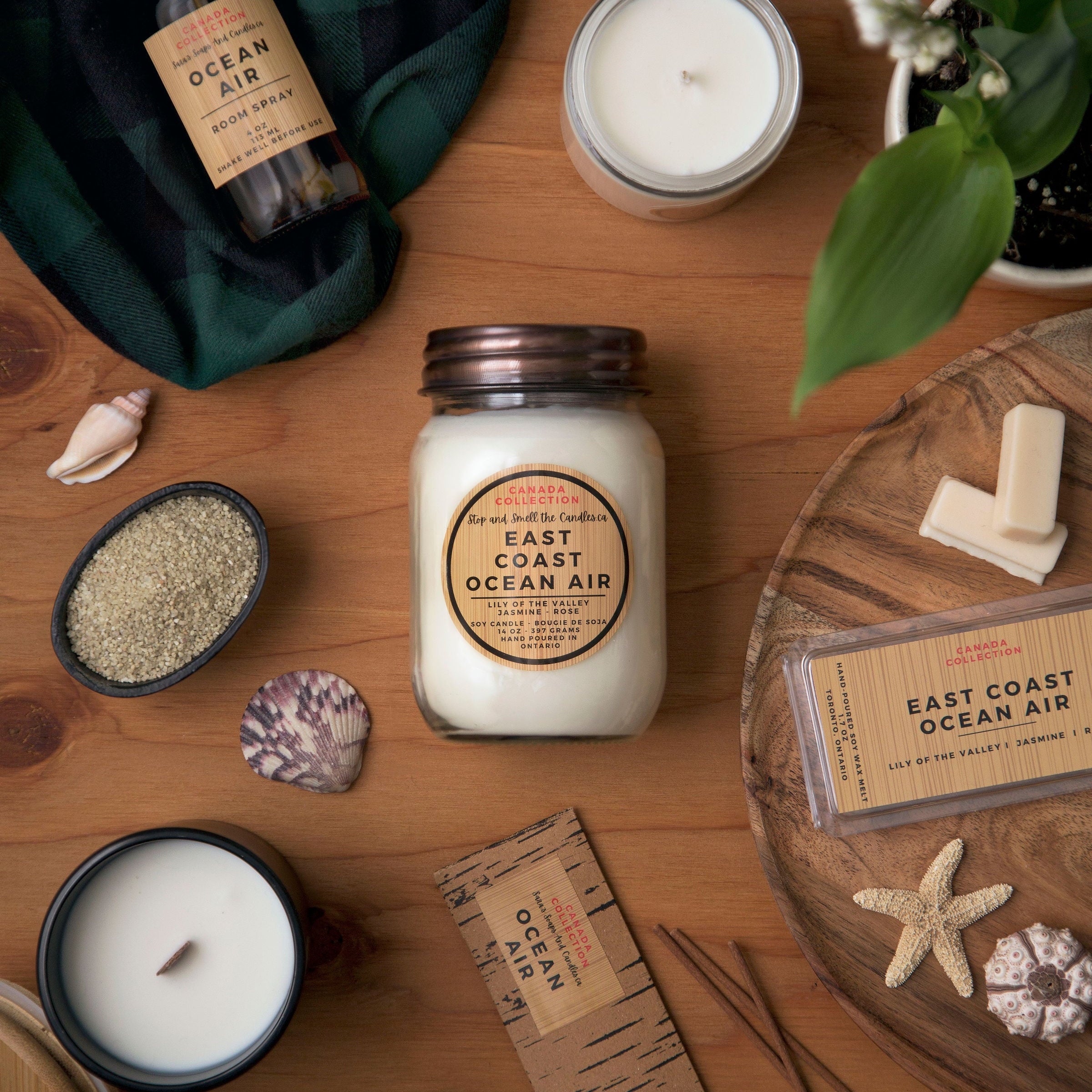Candles and decorative items on a wooden surface with 'East Coast Ocean Air' branding.
