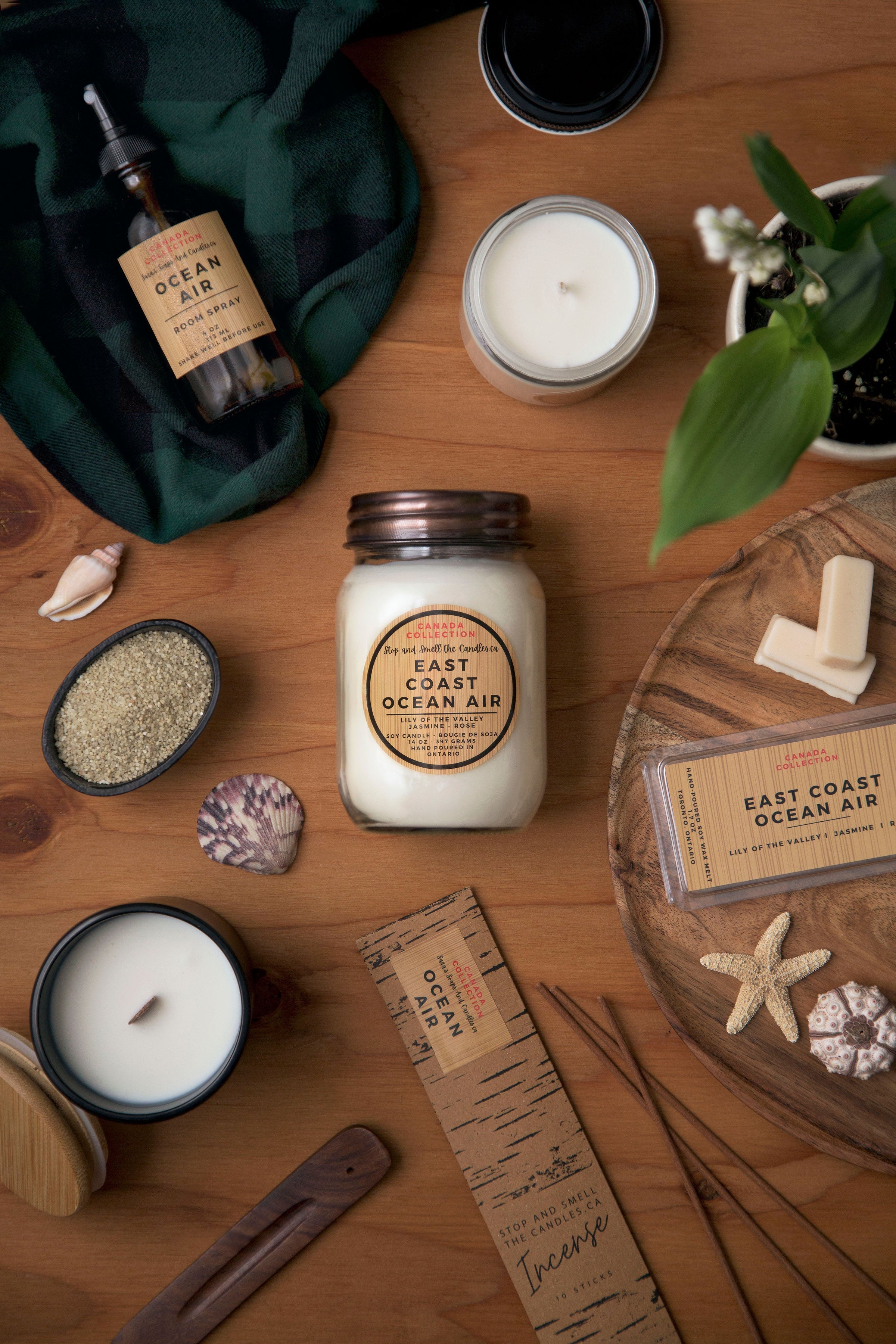 Candles and decorative items on a wooden surface with 'East Coast Ocean Air' branding.