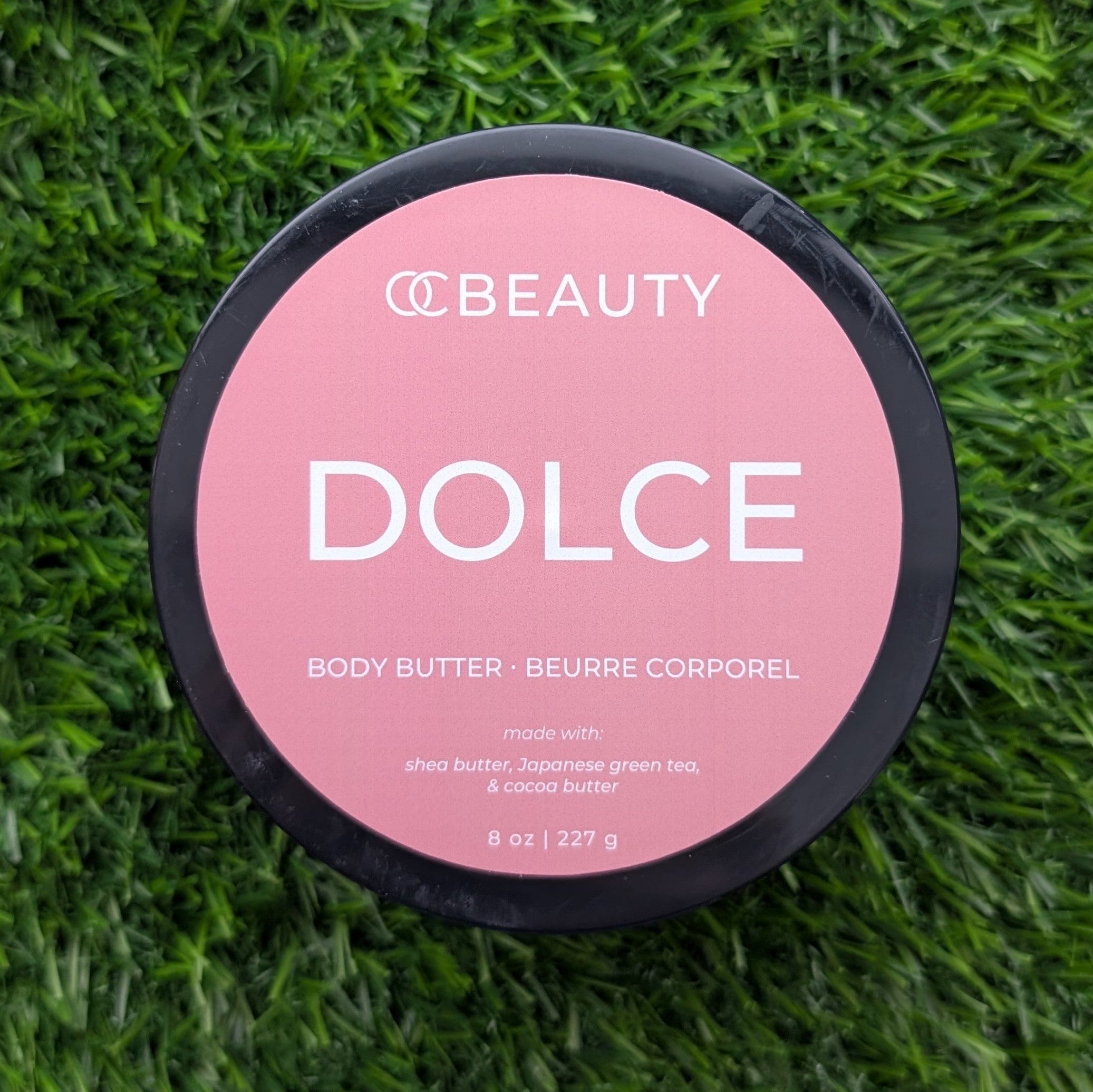 OC Beauty Body butter container labeled 'Dolce' on a grass background