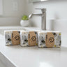 Three bars of soap with a bee design on a white countertop.