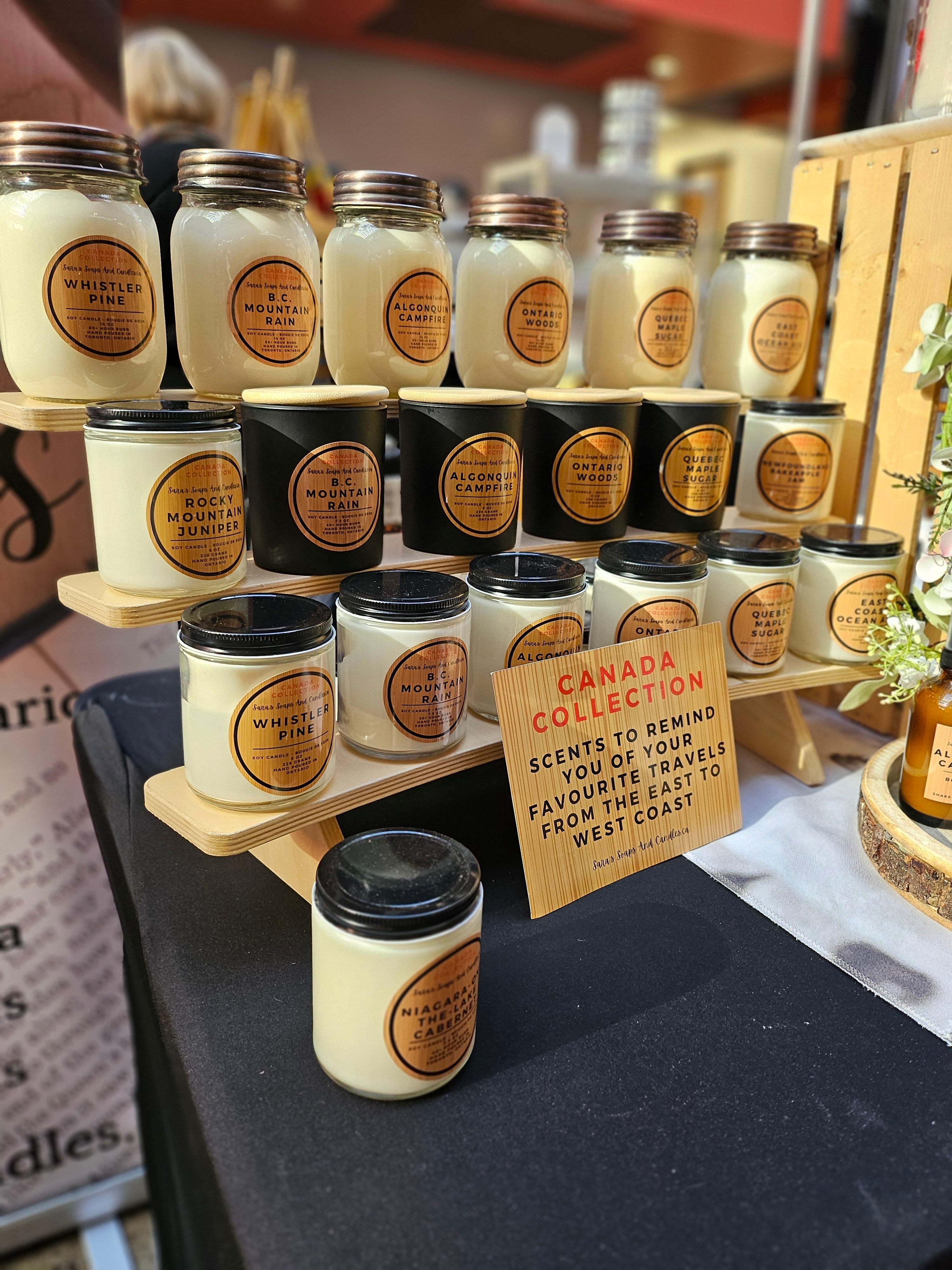 Display of candles with 'Canada Collection' sign on a table