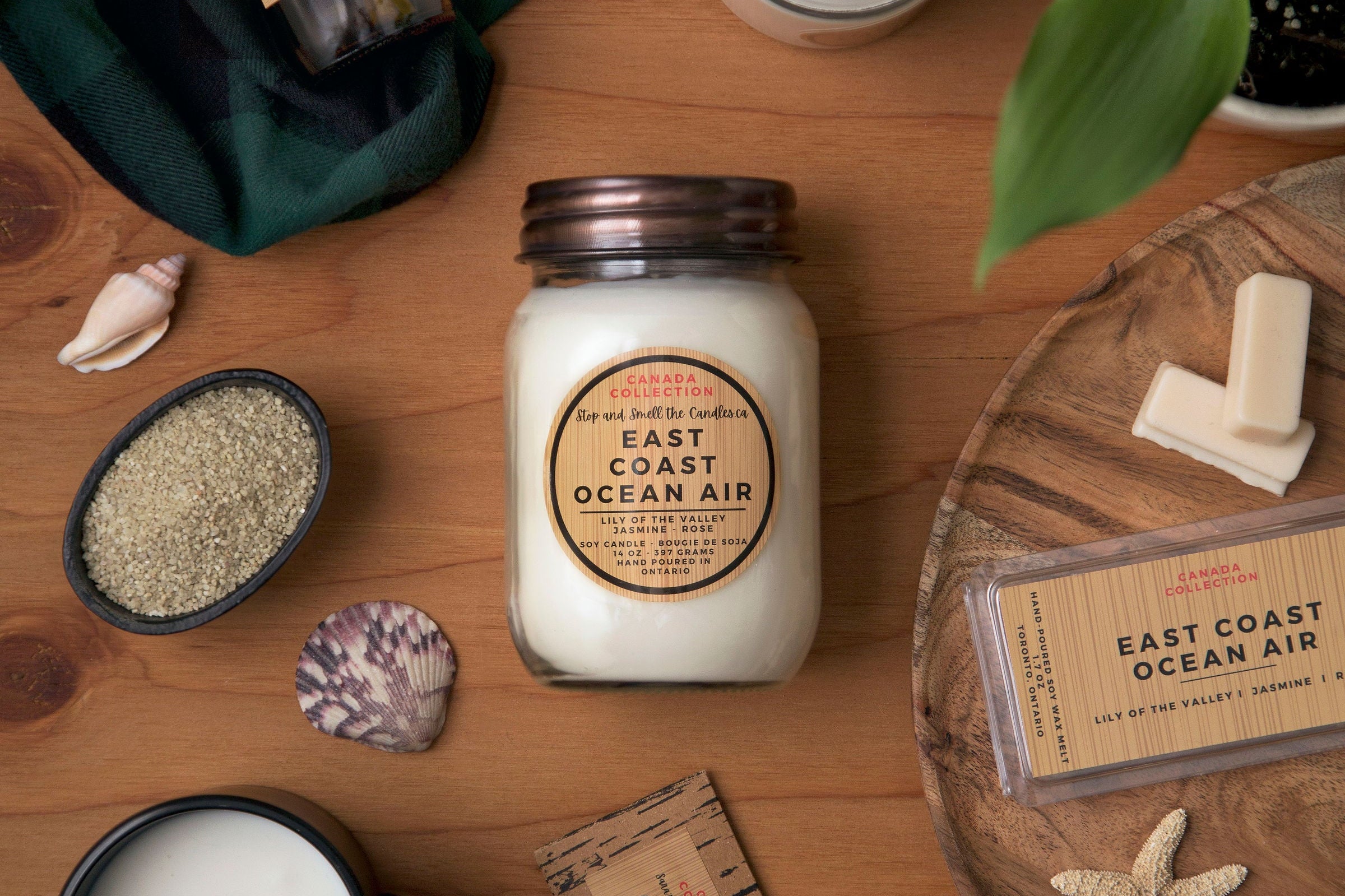 Candles and decorative items on a wooden surface with 'East Coast Ocean Air' branding from Stop and Smell the Candles
