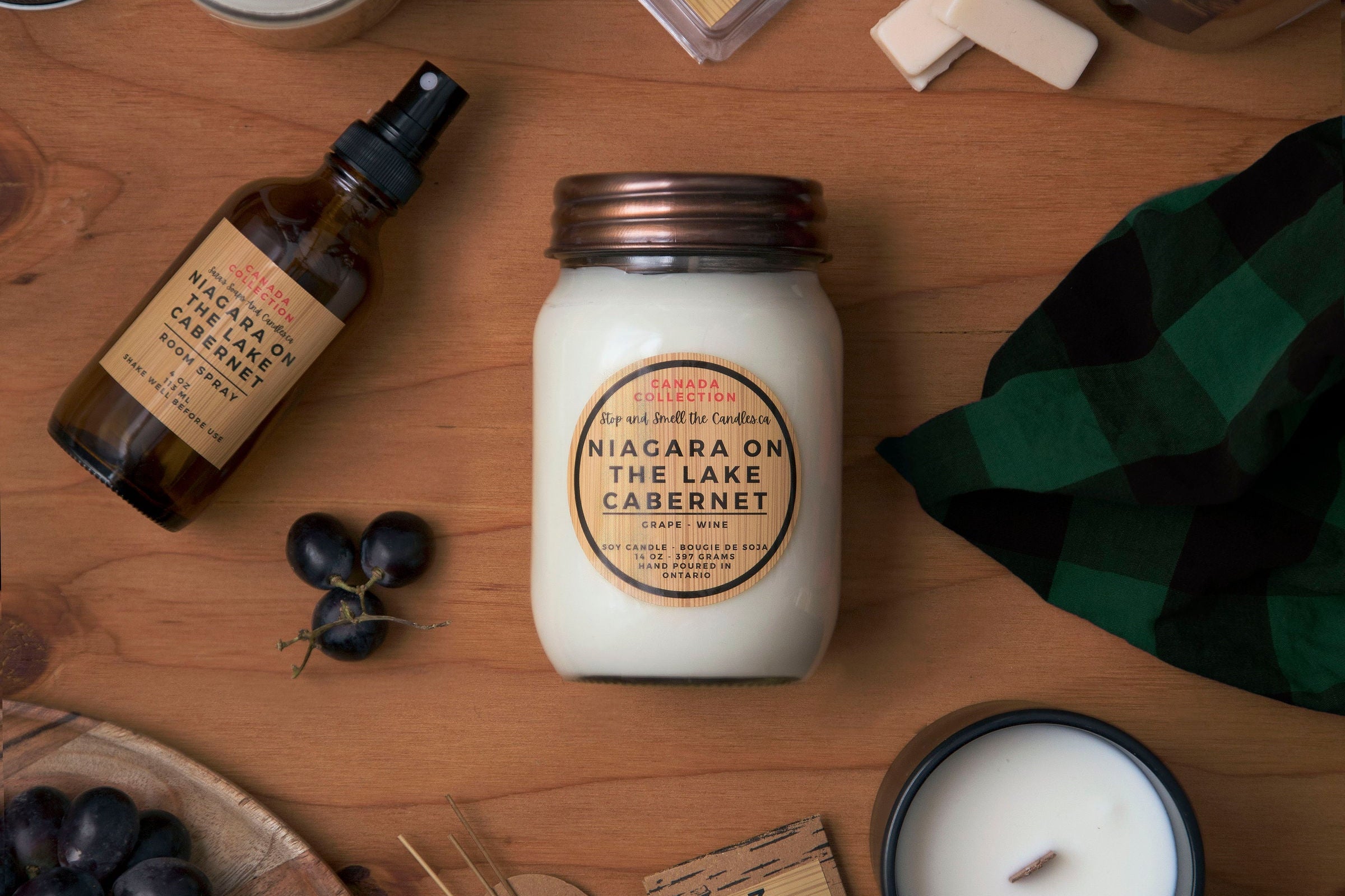 Assorted products including candles, bottles, and a jar on a wooden surface.