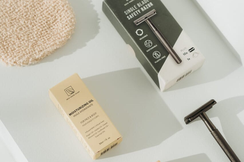 Men's grooming products including a safety razor, soap, and cream on a white surface.