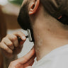 Person shaving their neck with a razor