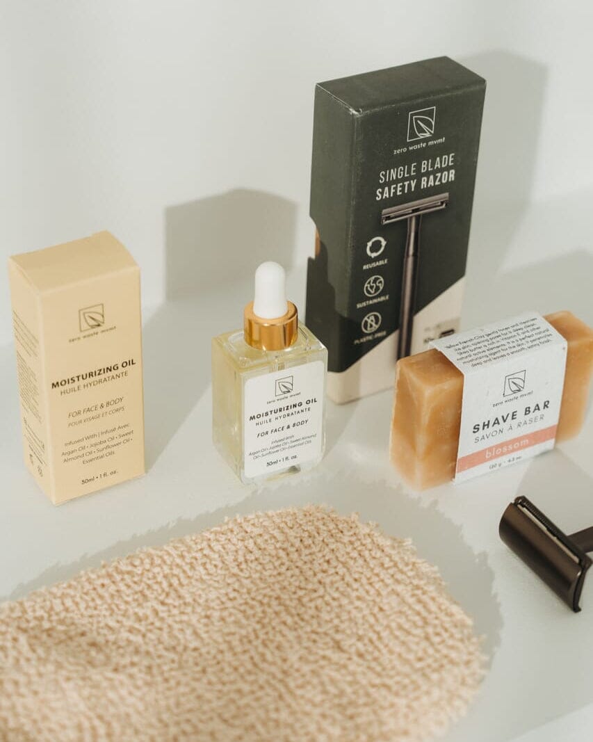 Skincare and grooming products including a bottle, box, and bar on a textured surface.