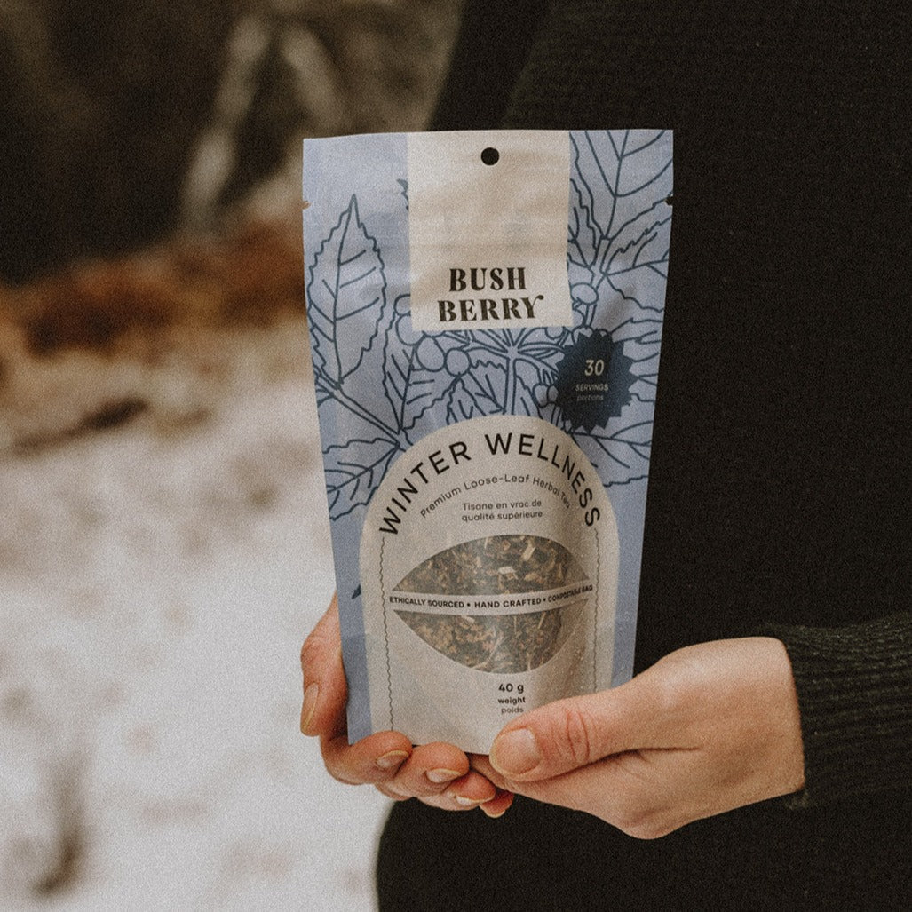 Hand holding Tea – Organic Winter Wellness | Bush Berry against a blurred natural background