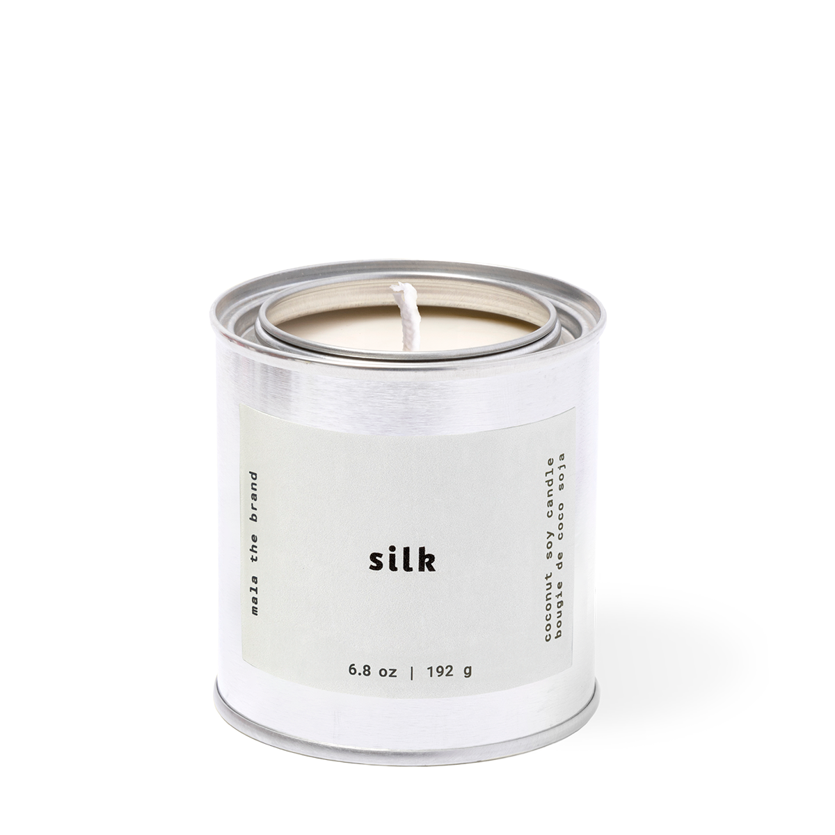 Candle in a silver container labeled 'silk' on a white background