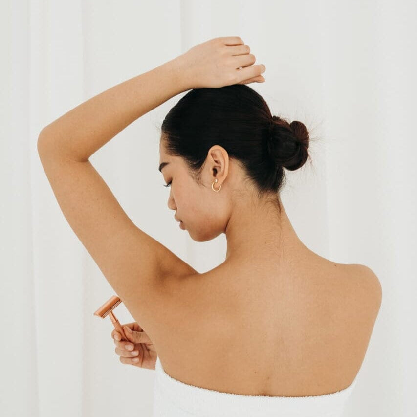 Woman with a bun holding a small object against a white background
