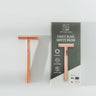 Rose gold safety razor with packaging on a white background