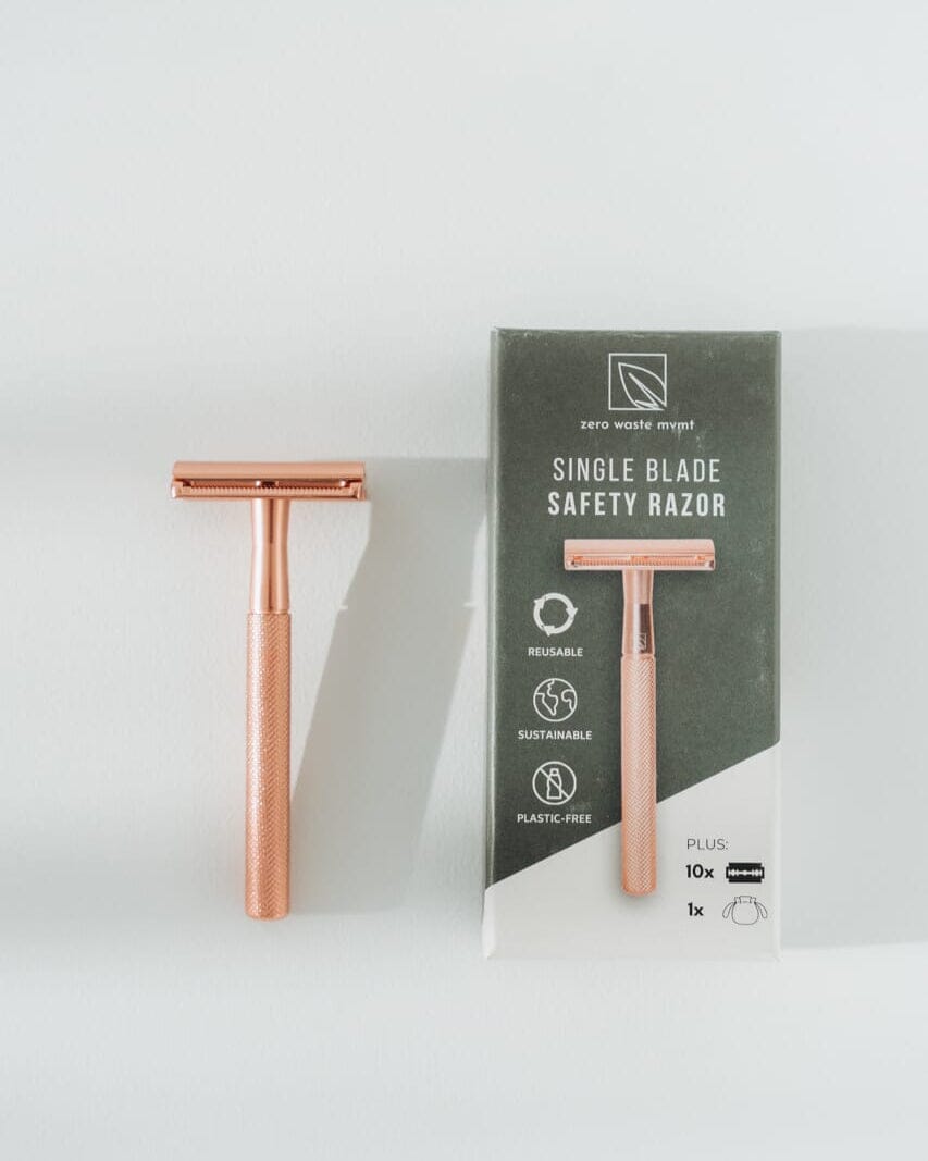 Rose gold safety razor with packaging on a white background