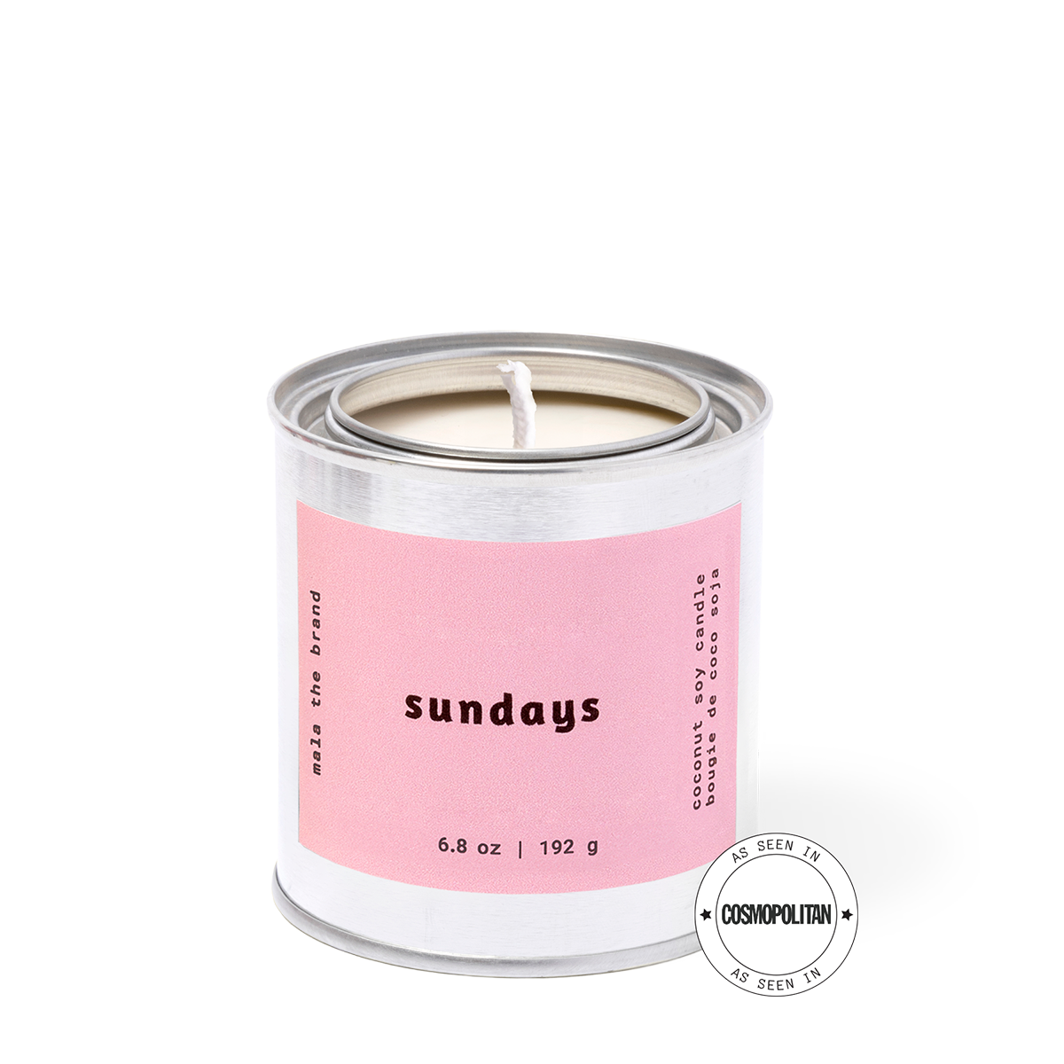 Candle in a metal tin with a pink label on a white background