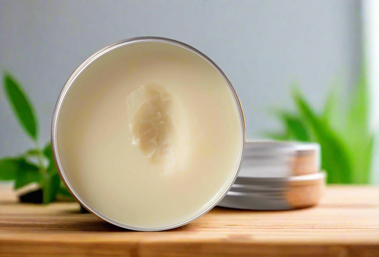 Metallic container with a white substance on a wooden surface with greenery in the background