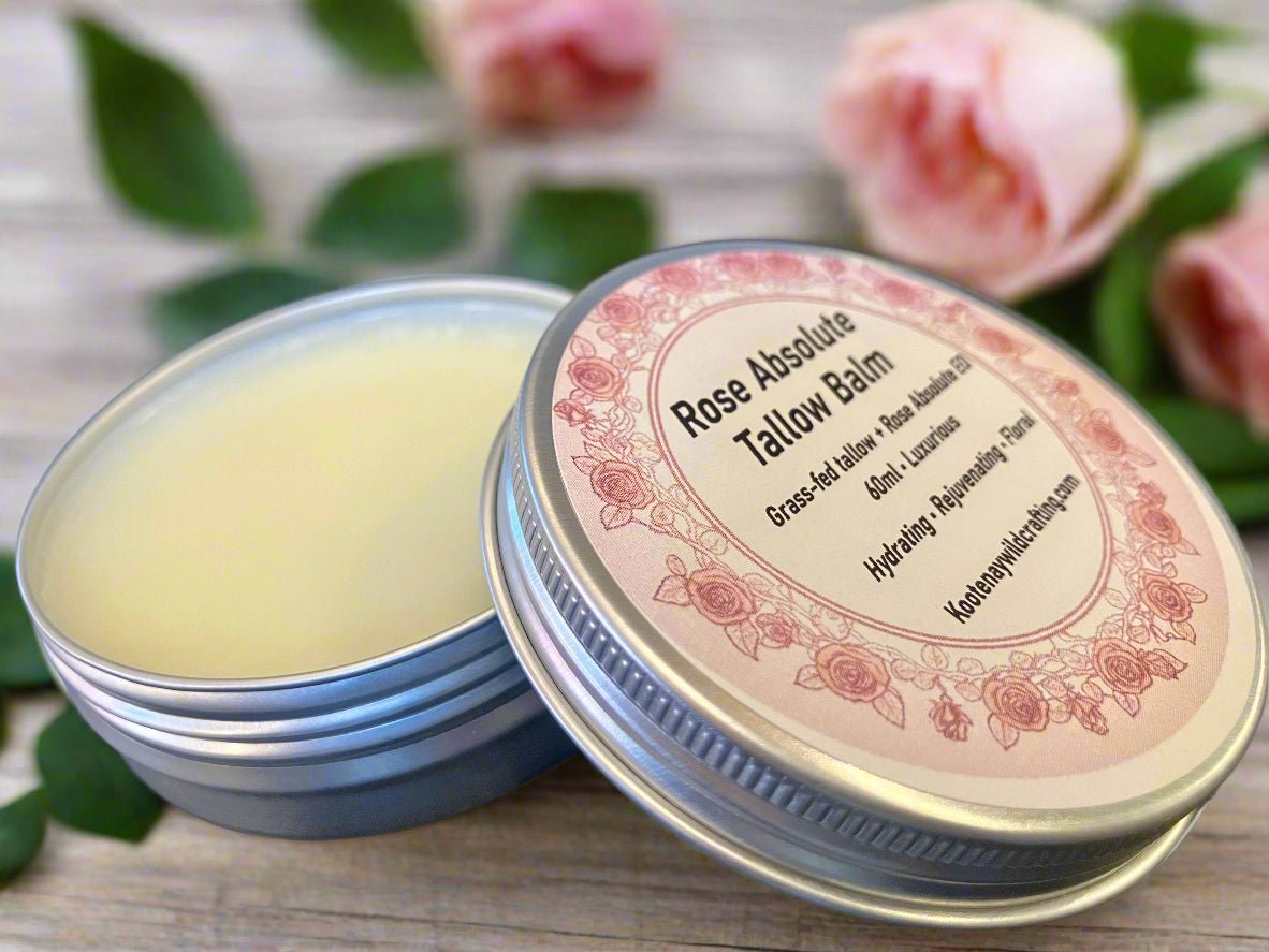 Rose Absolute Tallow Balm with a decorative label on a wooden surface with flowers in the background