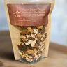 Package of Warm Earth Chaga Turmeric Tea Blend with visible tea leaves on a wooden surface.