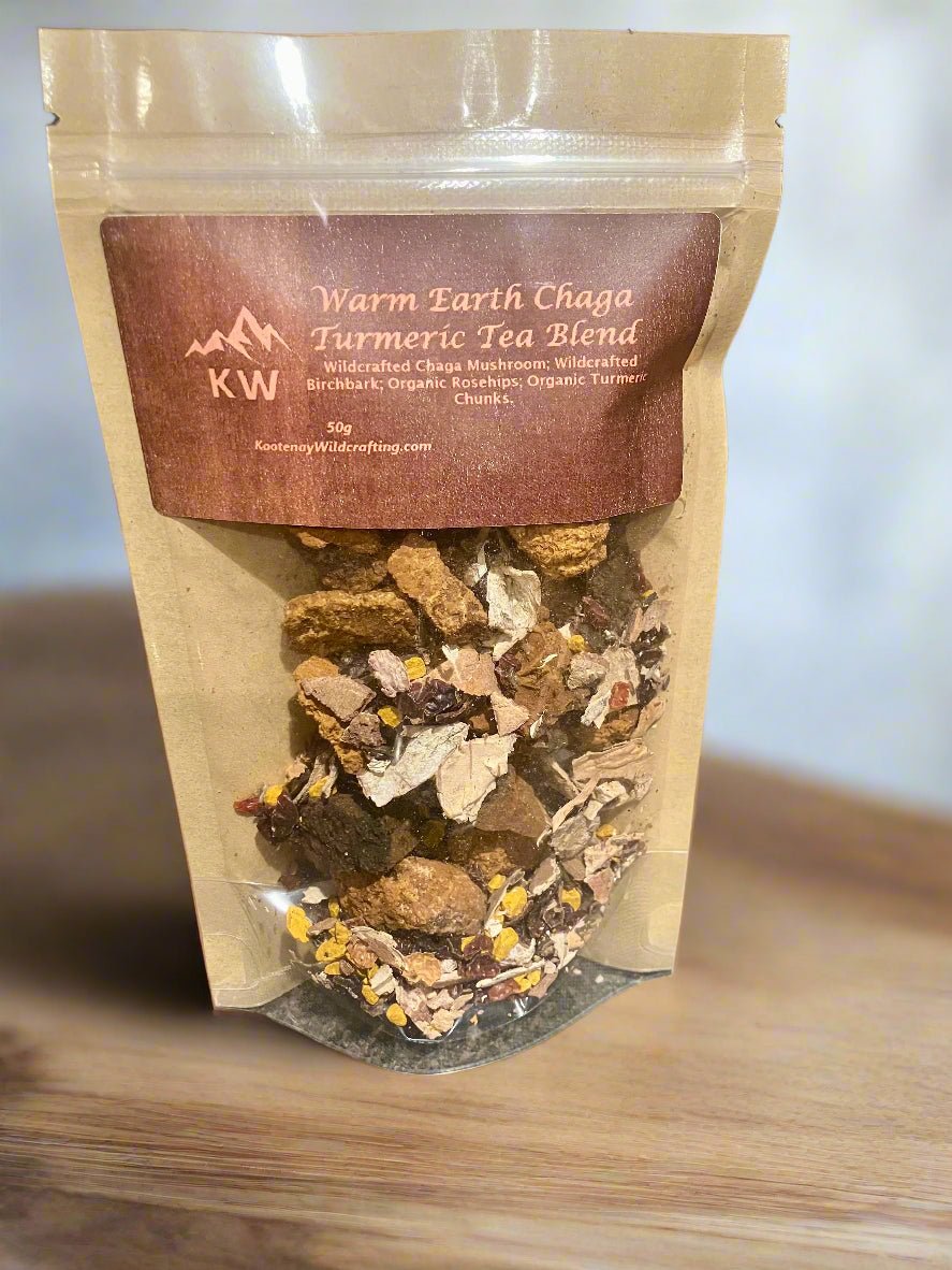 Package of Warm Earth Chaga Turmeric Tea Blend with visible tea leaves on a wooden surface.