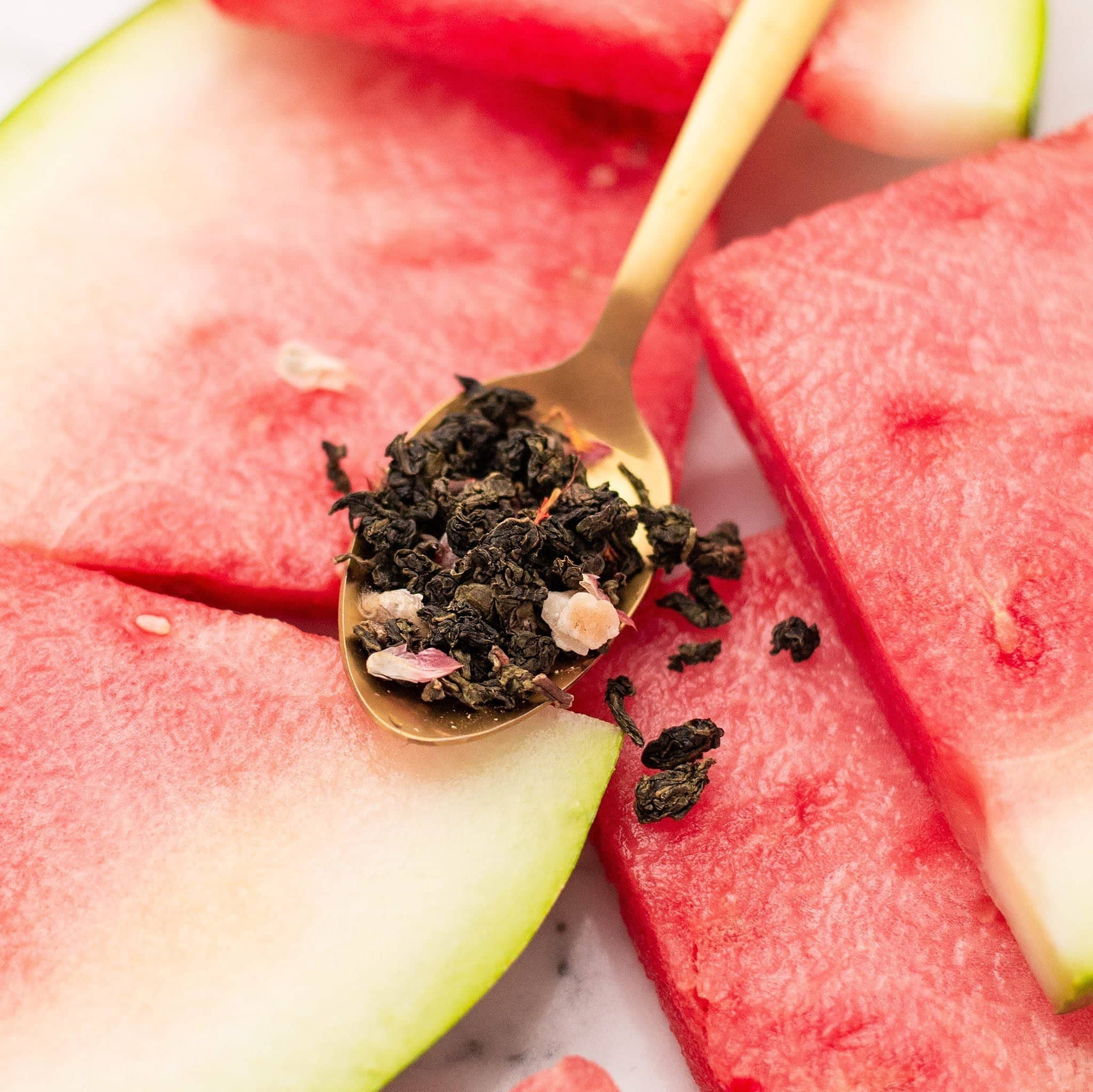 Gold spoon with tea leaves on watermelon slices